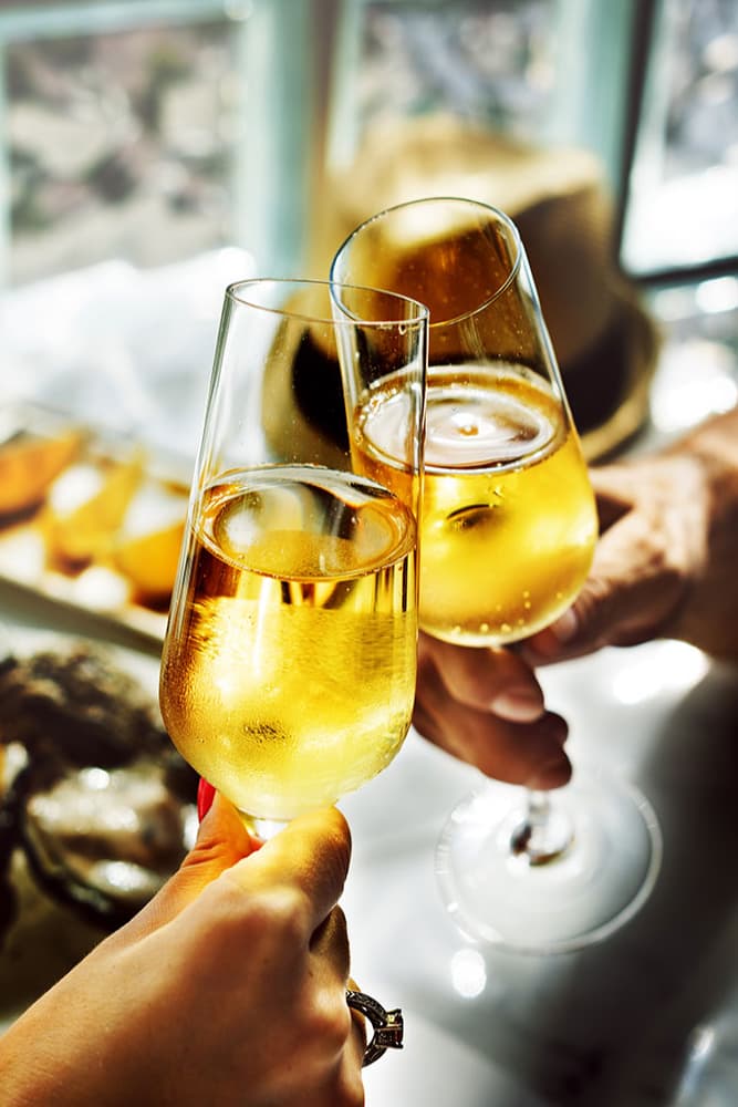 Two glasses of champagne are clinking in celebration.