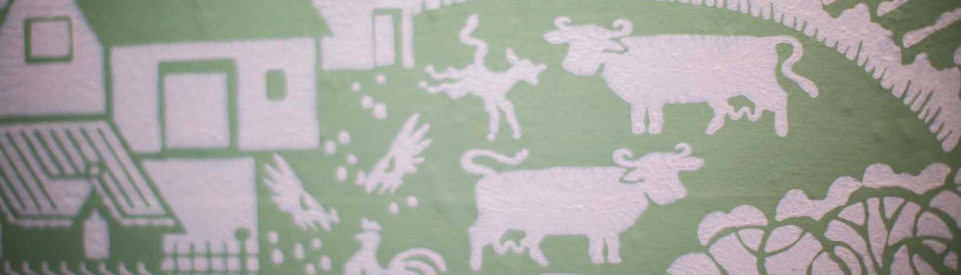 A decorative mural featuring farm animals and a house on a green background.